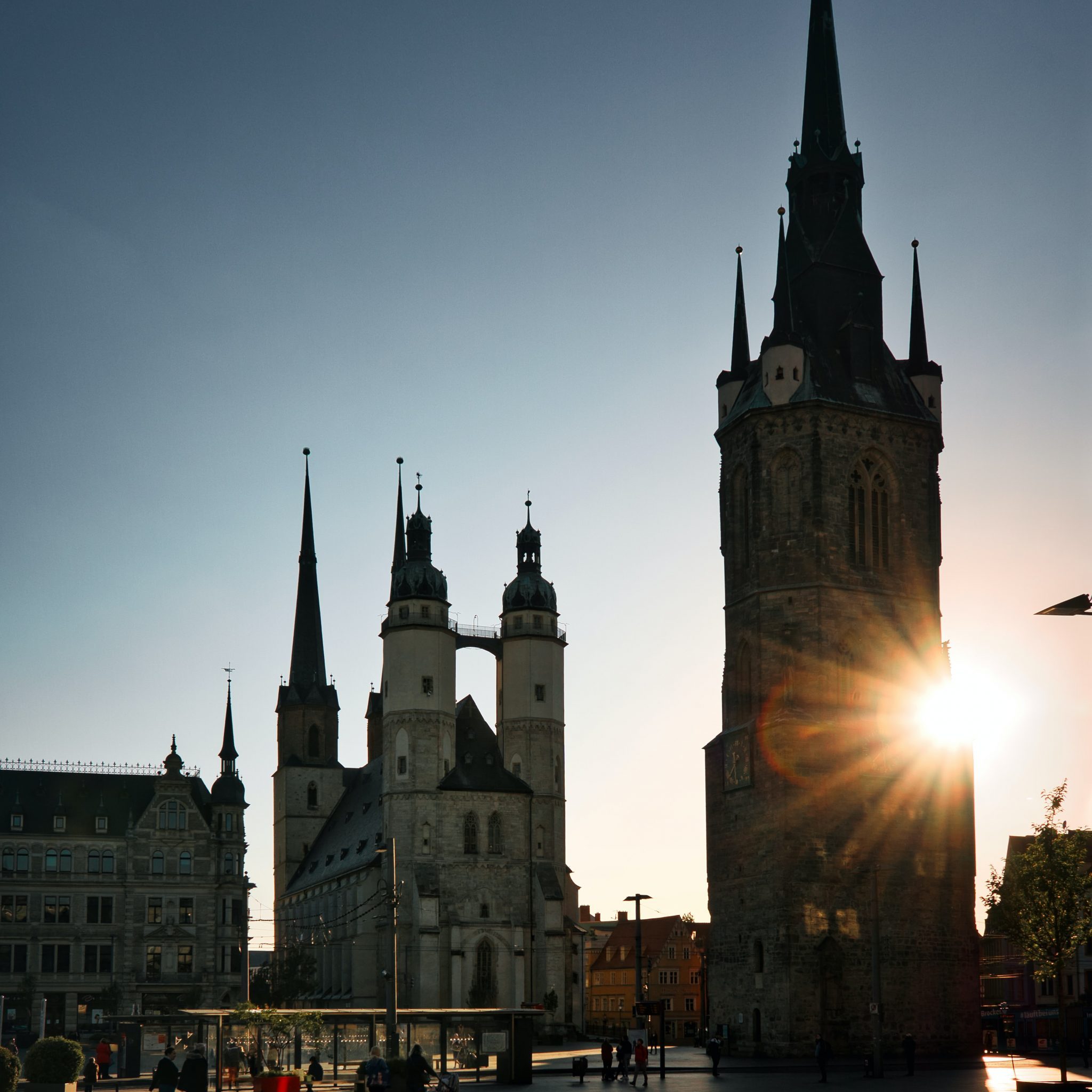 Halle Saale Wahrzeichen Marktkirche und Roter Turm vor untergehender Sonne und wolkenfreiem Himmel